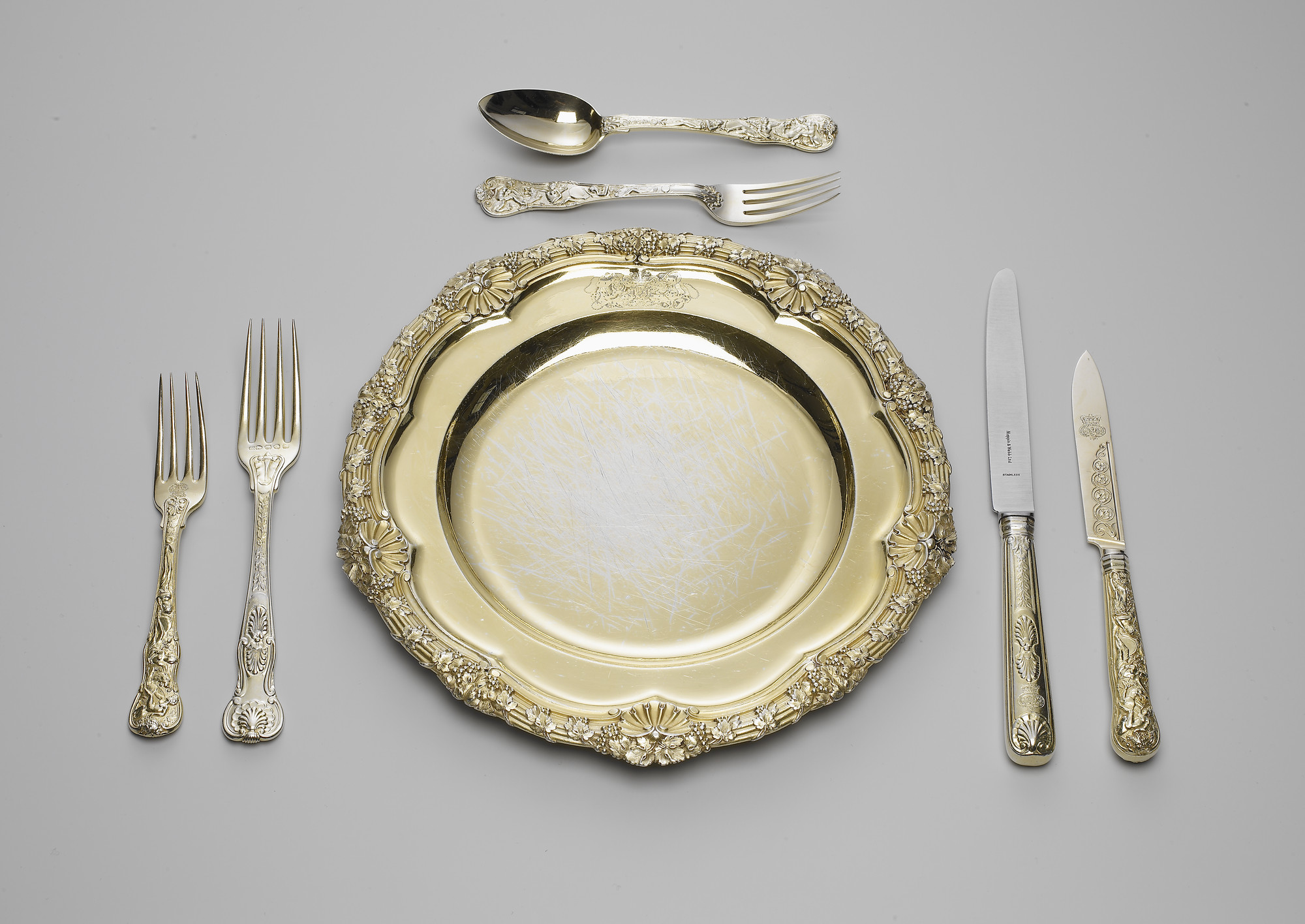 Dessert plate (part of The Grand Service) A set of silver-gilt plates; the reeded rim cast with fruiting vines and scallop shells. The plate is engraved with the Royal coat of arms, with supporters, mantling and coronet.